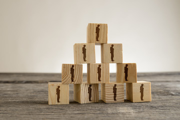 Blocks with businessman silhouettes structured into a pyramid