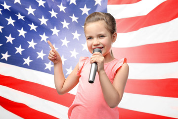Cute little girl with microphone on white background
