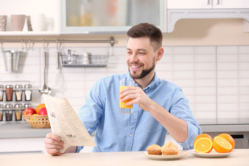 Handsome man with juice in kitchen