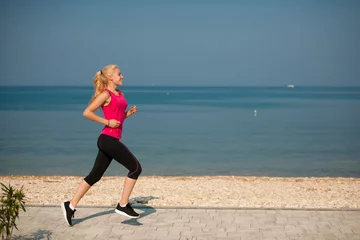 Papier Peint photo autocollant Jogging jogging sur la plage - une femme court près de la mer au début de l& 39 été matin