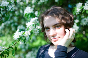 Portrait of a young beautiful girl in a flowering tree. Beauty of springtime without allergy