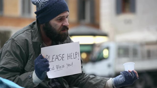 Homeless alone and sadly asks charity in the street