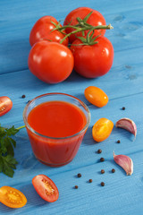 Tomato juice and vegetables on blue board, healthy nutrition