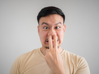 Headshot of smell something bad face of Asian man.