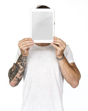 Man holding tablet covering his face