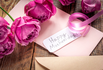 pink peony and greeting-card for Mother's day present on wooden background
