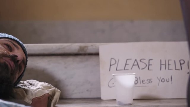 Sexy woman with green shoes giving money to a homeless sleeping on the stairs