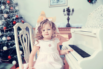 Little girl plays music on the piano.