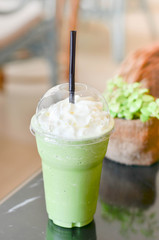 green tea latte frappe on table in cafe