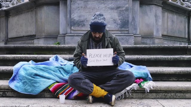 Sad Homeless alone in the street waiting for people give him money