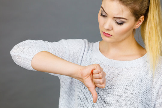 Sad woman showing thumb down gesture