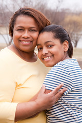 African American mother and her daughter smiling.