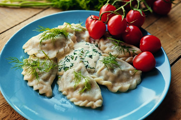 Delicious dumplings with parsley on a blue plate.