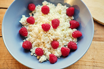 Diet curd with raspberry on a plate.