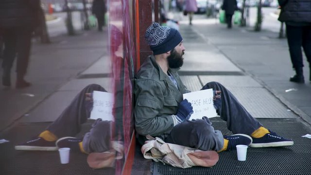 Homeless on the street receives charity from a pedestrian