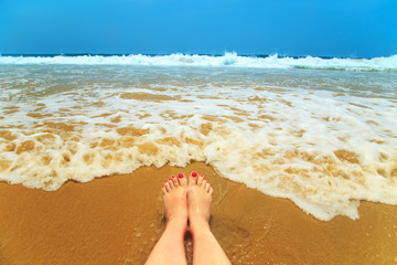 Woman legs on the beach.