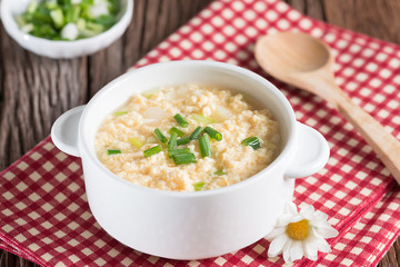 Egg drop soup in white bowl.