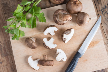 Sliced of Shiitake mushroom on wooden cutting board. Top view.