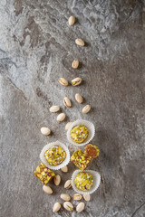 Fototapeta na wymiar Eastern sweets. Turkish delight with pistachios in a vase. Dark gray stone background.