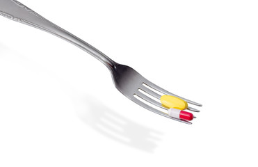 Different dietary supplements on the fork closeup