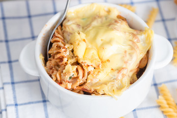 Baked pasta gratin in white bowl.