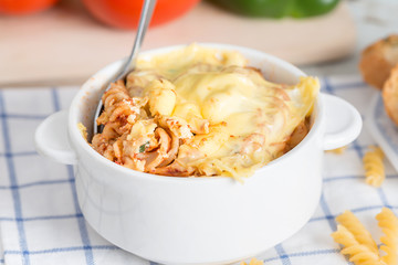 Baked pasta gratin in white bowl.
