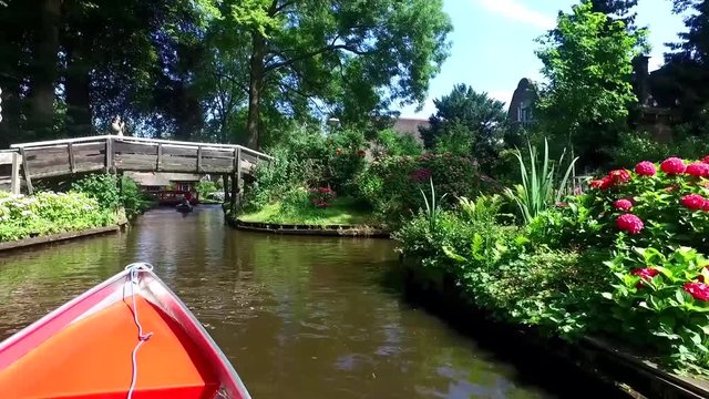 Landscape view of thatched rustic roof houses around canals in famous village Giethoorn.