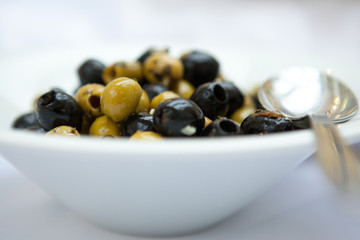 green and black olives in porcelain plate