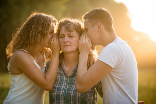Siblings sharing each other's secret with mother