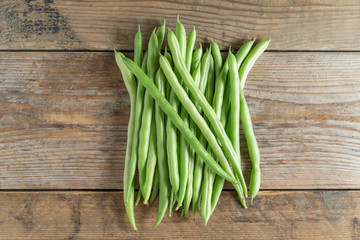 Green bean on wood background. Top view.