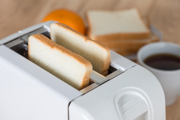 Close up, Bread in toaster with coffee.