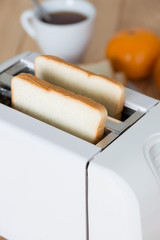 Close up, Bread in toaster with coffee.