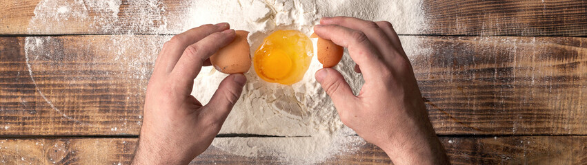 Male hands beat the egg yolk into the flour