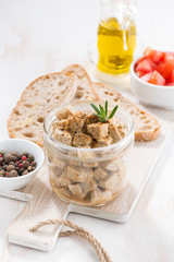 marinated feta in a glass jar, vertical