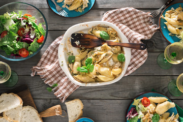 Dinner table with pasta, fresh salad and white wine