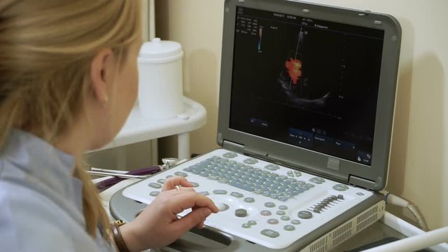 Echocardiography. Female doctor examining a patient's heart by using an ultrasound equipment. HD