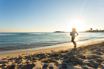young healthy lifestyle fitness woman running at sunrise beach