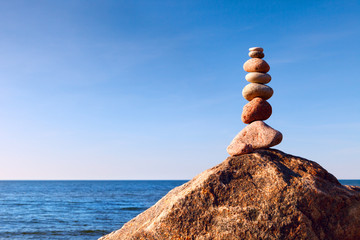 Pyramid of stones on top of a cliff. The concept of balance