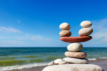 Stones balance on the background of sea and blue sky