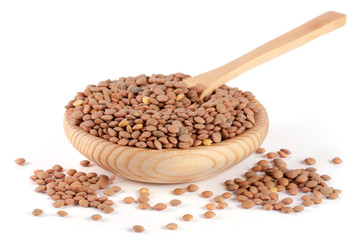 Lentils in a wooden bowl with a spoon isolated on a white background