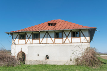 single plain house with intersting wood beans walls and hills in the background