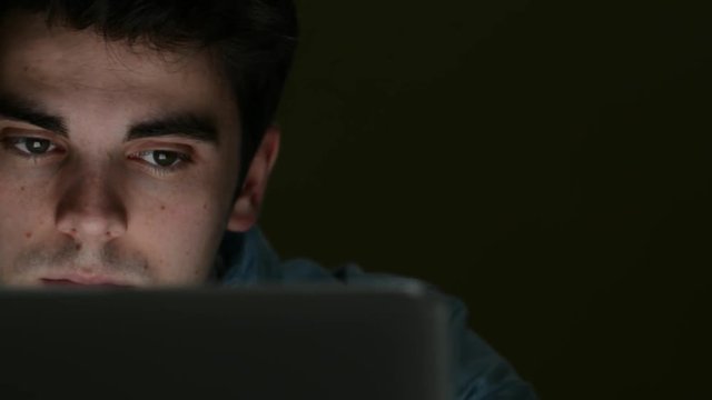 Tired Young Man Working On Laptop Late At Night