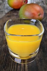fresh mango juice and mango fruit on wooden decking