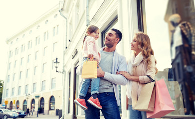 Obraz premium happy family with child and shopping bags in city