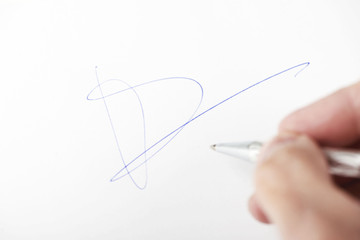 Male hand signing on white paper.