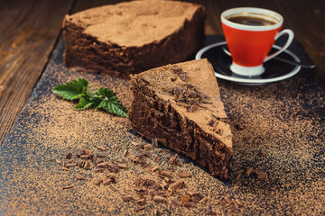 chocolate cake with Candies and cup of coffee,Chocolate cake with a cut piece and blade on gray background,closeup,Dark chocolate cake,vegan chocolate cake,Tasty chocolate cake on wooden background