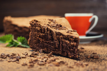 chocolate cake with Candies and cup of coffee,Chocolate cake with a cut piece and blade on gray background,closeup,Dark chocolate cake,vegan chocolate cake,Tasty chocolate cake on wooden background