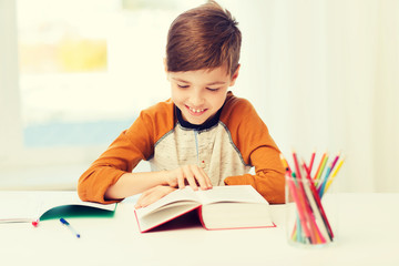 smiling, student boy reading book at home