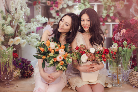 Beautiful asian women florists with bouquet of flowers in flower store