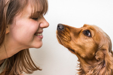 Cute dog kissing young woman